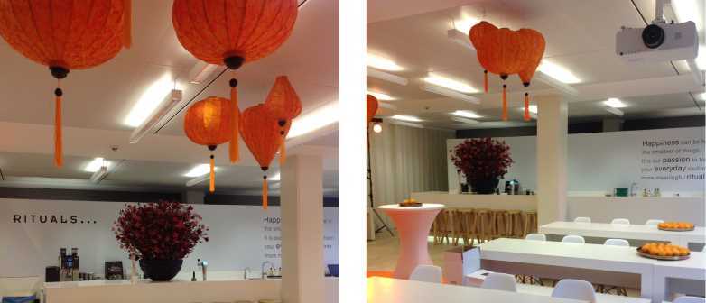 Oranje Vietnamese lampions aan het plafond die de beursstand van Rituals decoreren